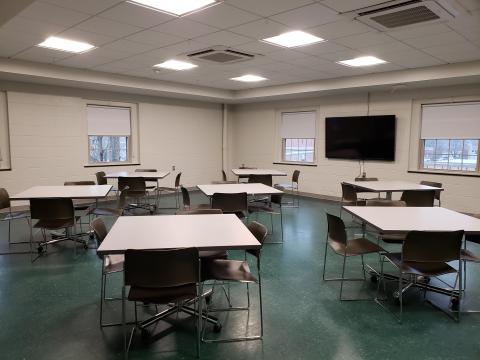 Shurtleff Room with various square tables spaced out and large tv mounted on wall